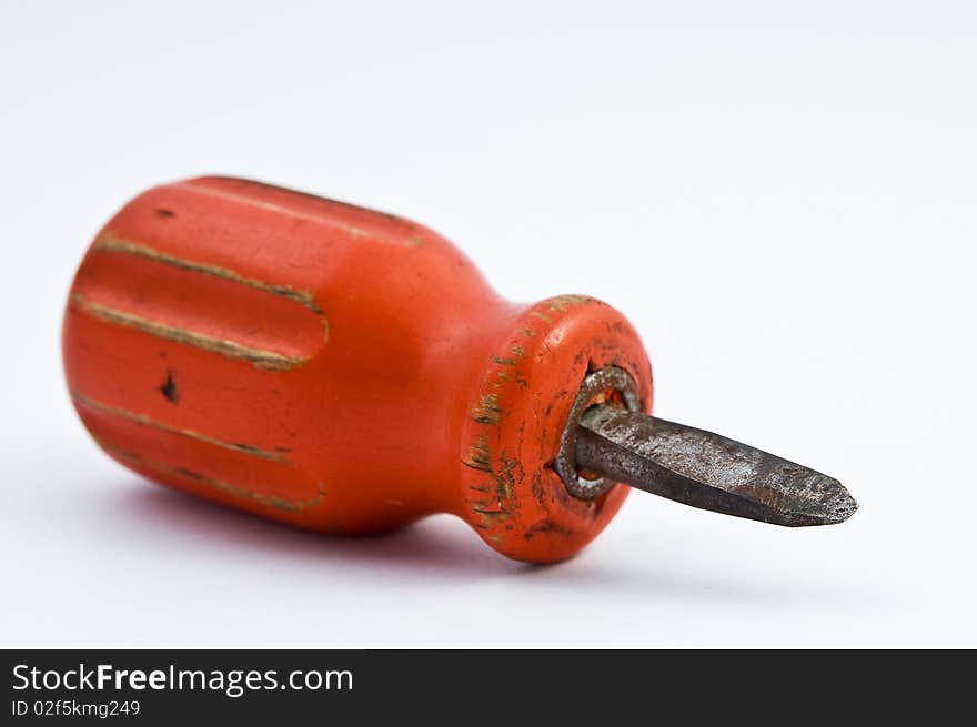 Small orange screwdriver on white underground