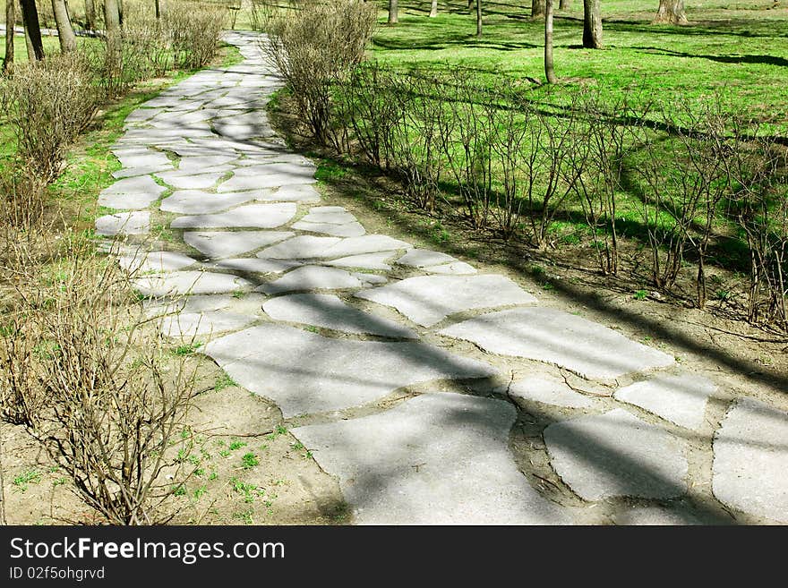 Stone path in the park with tree shadows. Stone path in the park with tree shadows