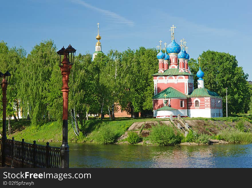 Red church in trees over river. Red church in trees over river