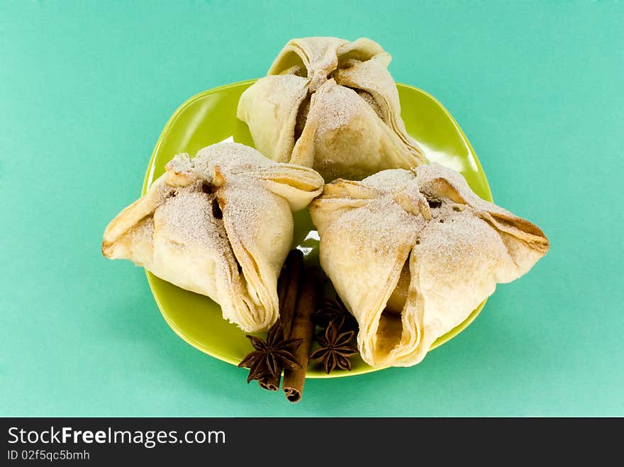 Small cakes on plate against green background