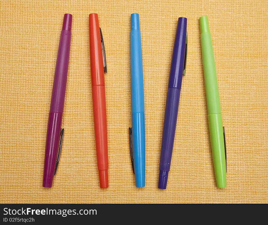 Vibrant Pens on Yellow Background for a cheerful modern office.