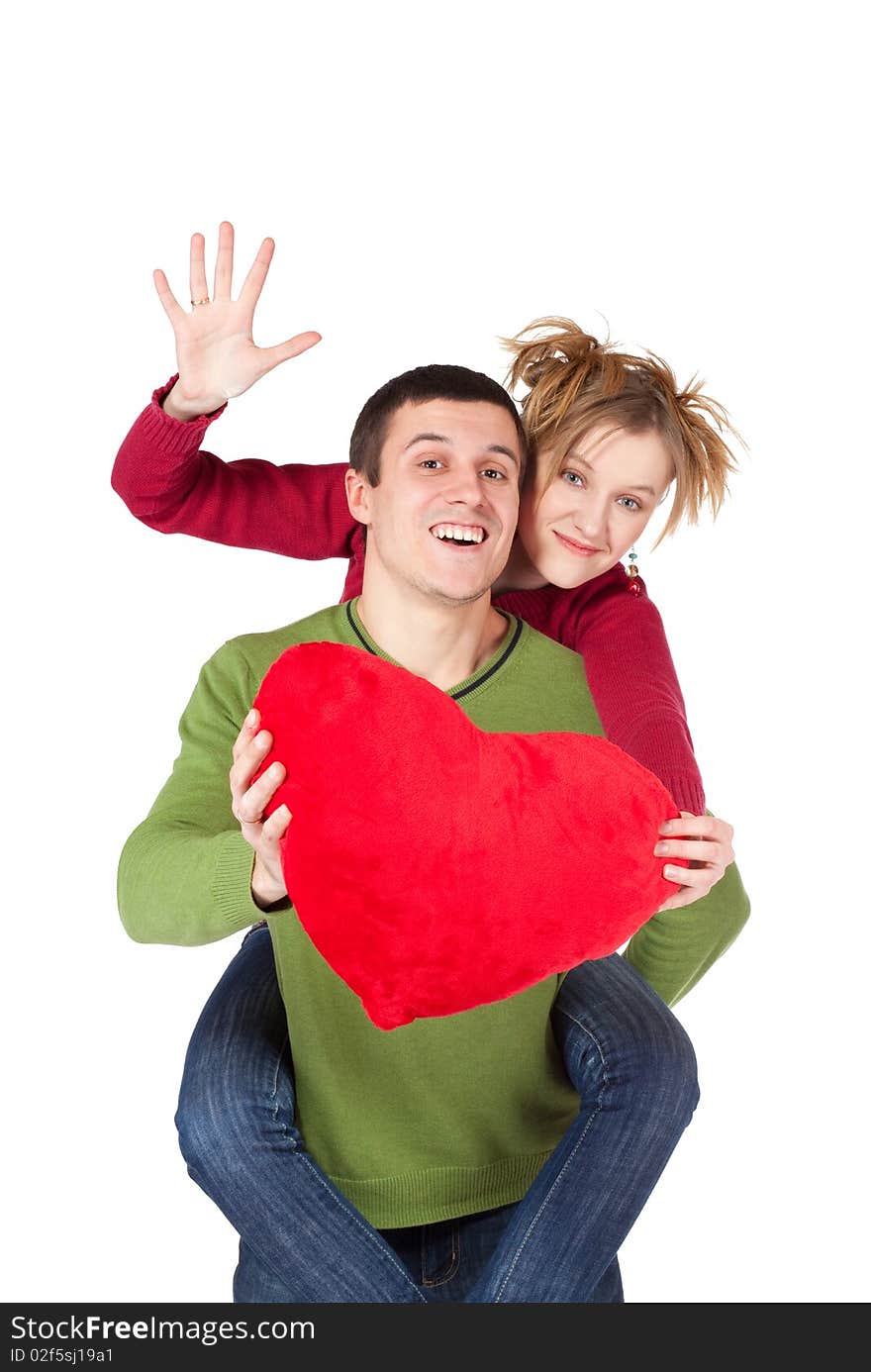 Young loving couple smiling with heart in hands looking at camera, beautiful woman sitting on handsome man