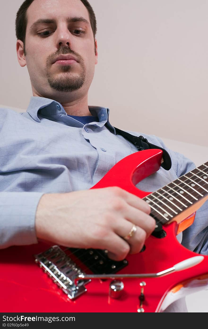 Young man, playing a red electric guitar. Young man, playing a red electric guitar