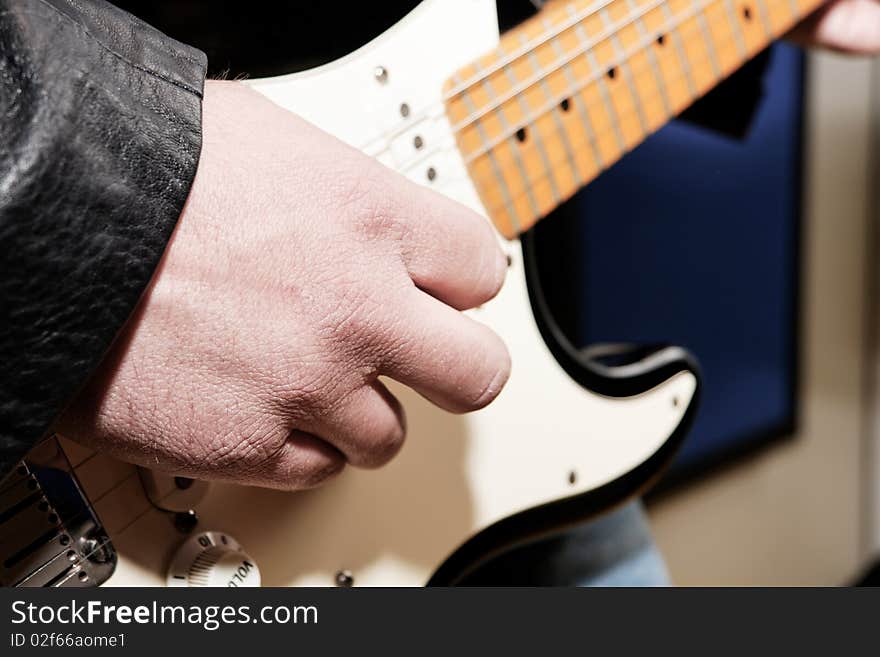 A guitar player's hand while playing an electric guitar. A guitar player's hand while playing an electric guitar