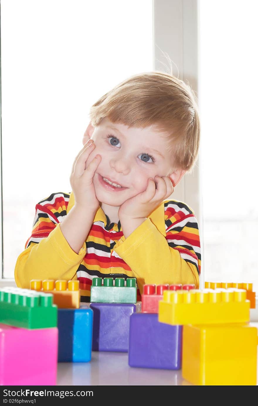 The beautiful little boy poses on a light background. The beautiful little boy poses on a light background