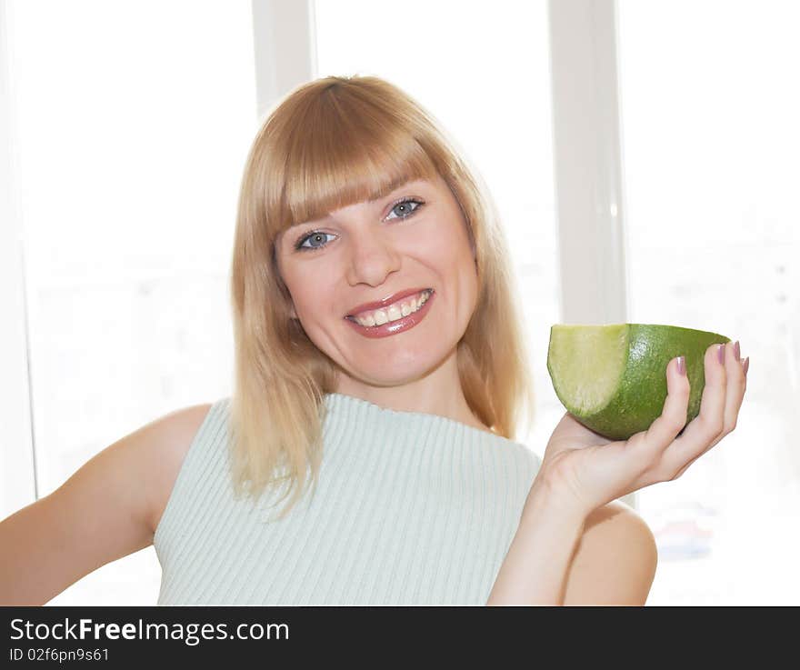 The young woman with a garden radish in a hand on a background