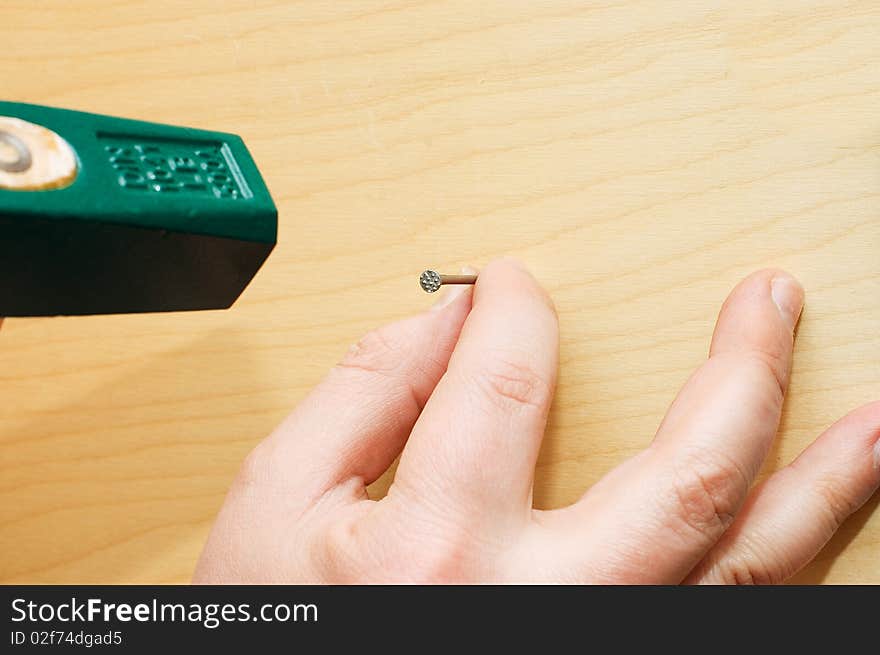 Man hammers a hammer in a nail close up