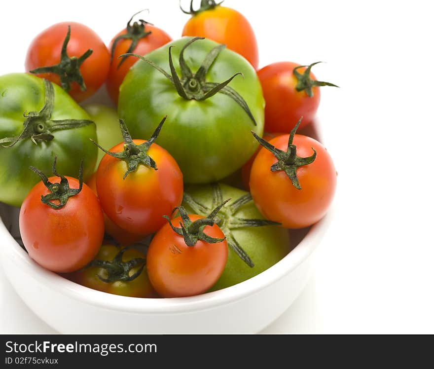 Red and green tomatoes in white bowl. Red and green tomatoes in white bowl