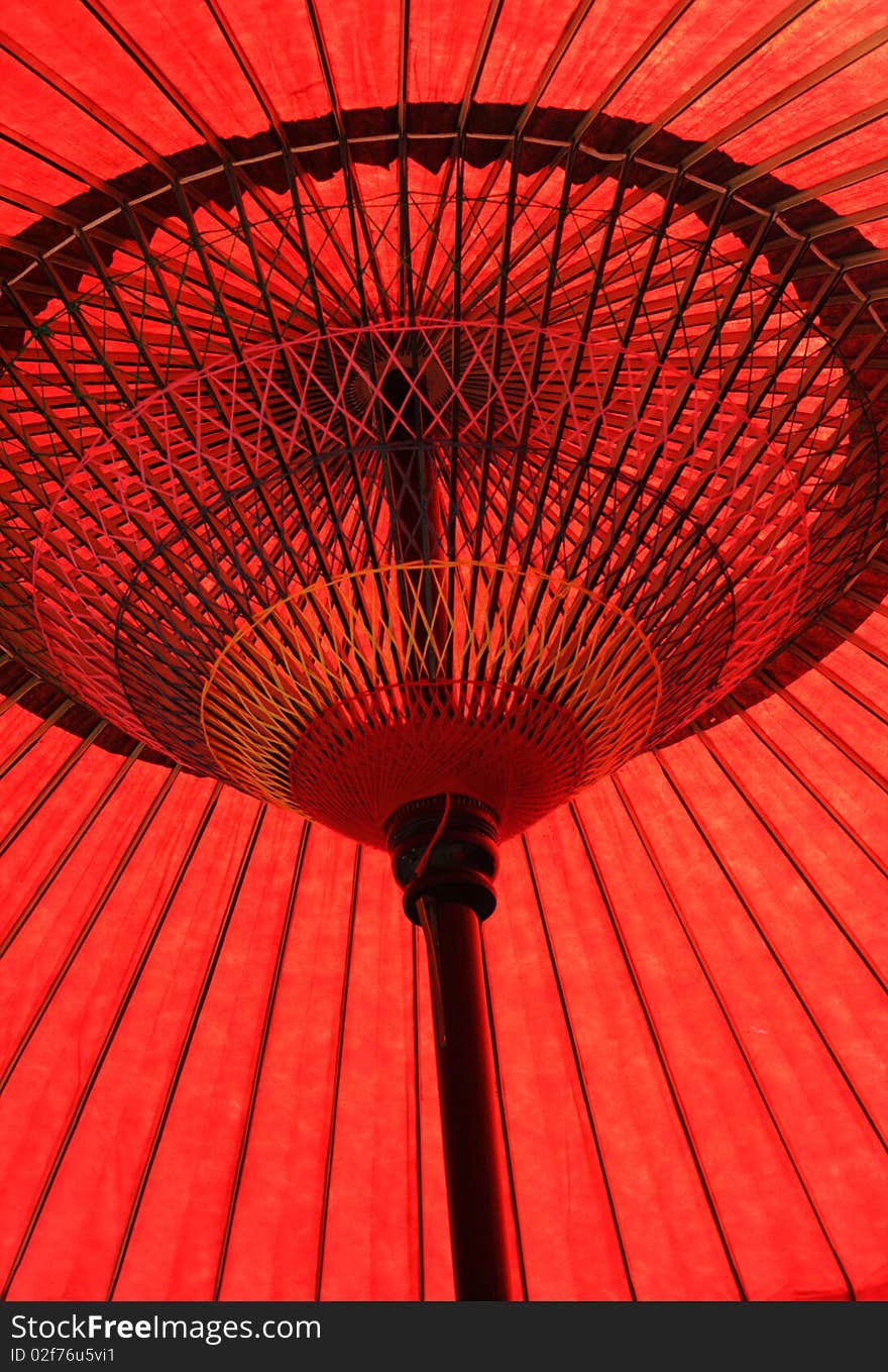 Red paper Japanese umbrella in a garden. Red paper Japanese umbrella in a garden.
