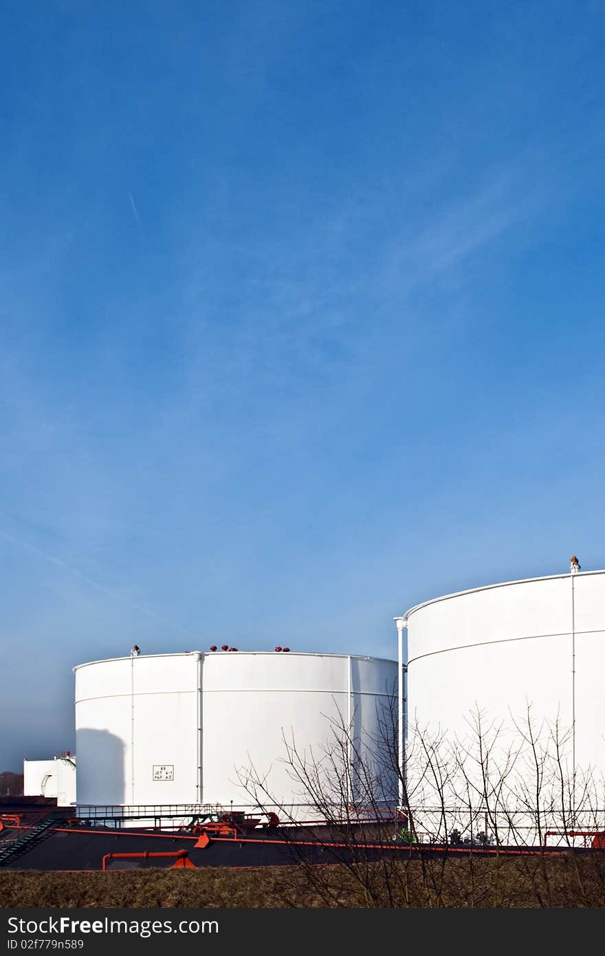 White tanks in tankfarm with staircase to enter the construction with blue sky, storage of petrol, oil. White tanks in tankfarm with staircase to enter the construction with blue sky, storage of petrol, oil