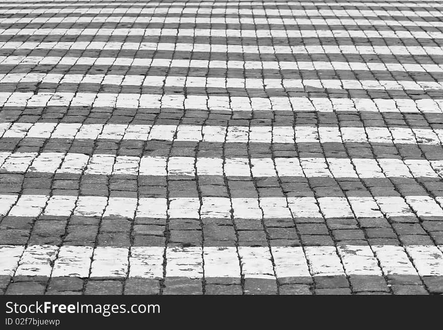 The pedestrian crossing on a pavement. Black and white.