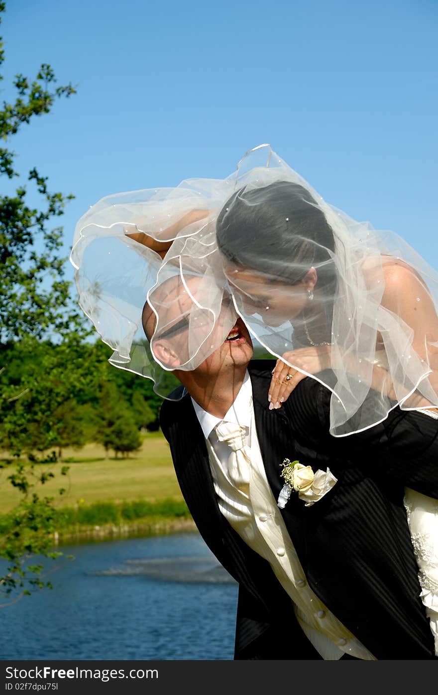 Groom is lifting his bride up in a park. Groom is lifting his bride up in a park.