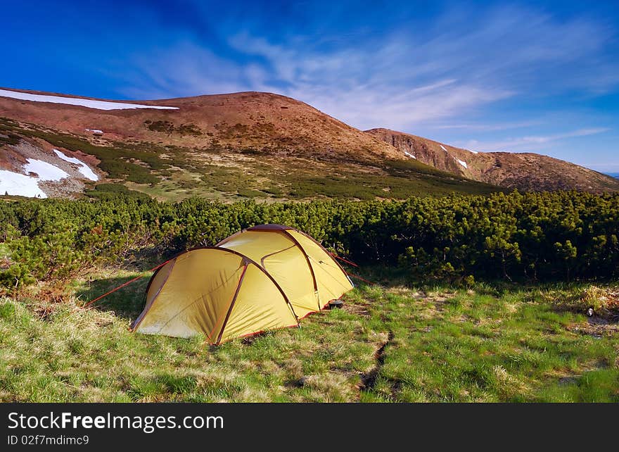 Camping in mountains. A solar landscape with tourist tent