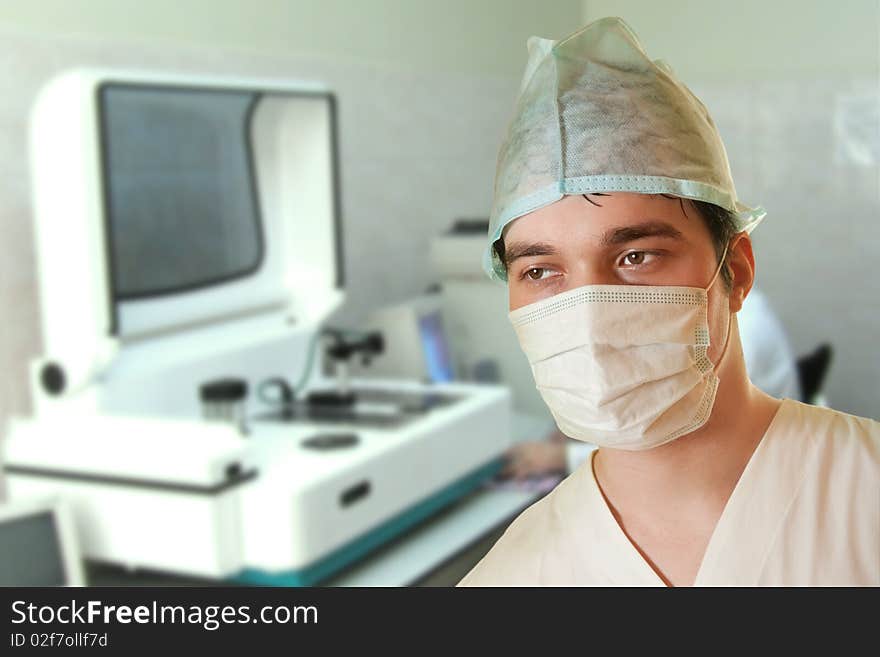 A portrait of a surgeon while an operation is being conducted in the background