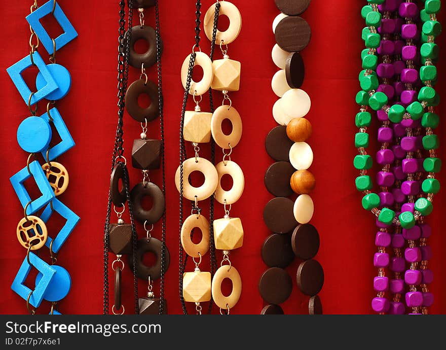 Colored necklaces over red background