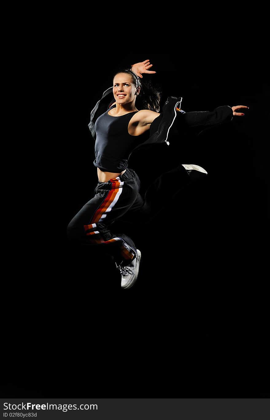 Female dancer jumping on a black background