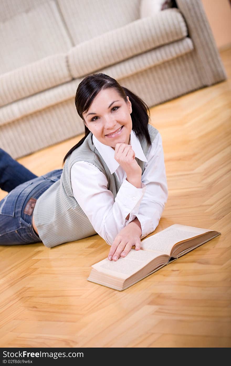 Youing brunette woman reading book at home