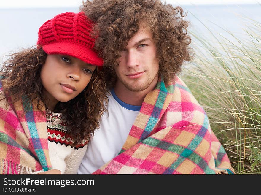 Young Couple Sitting In Sand Dunes