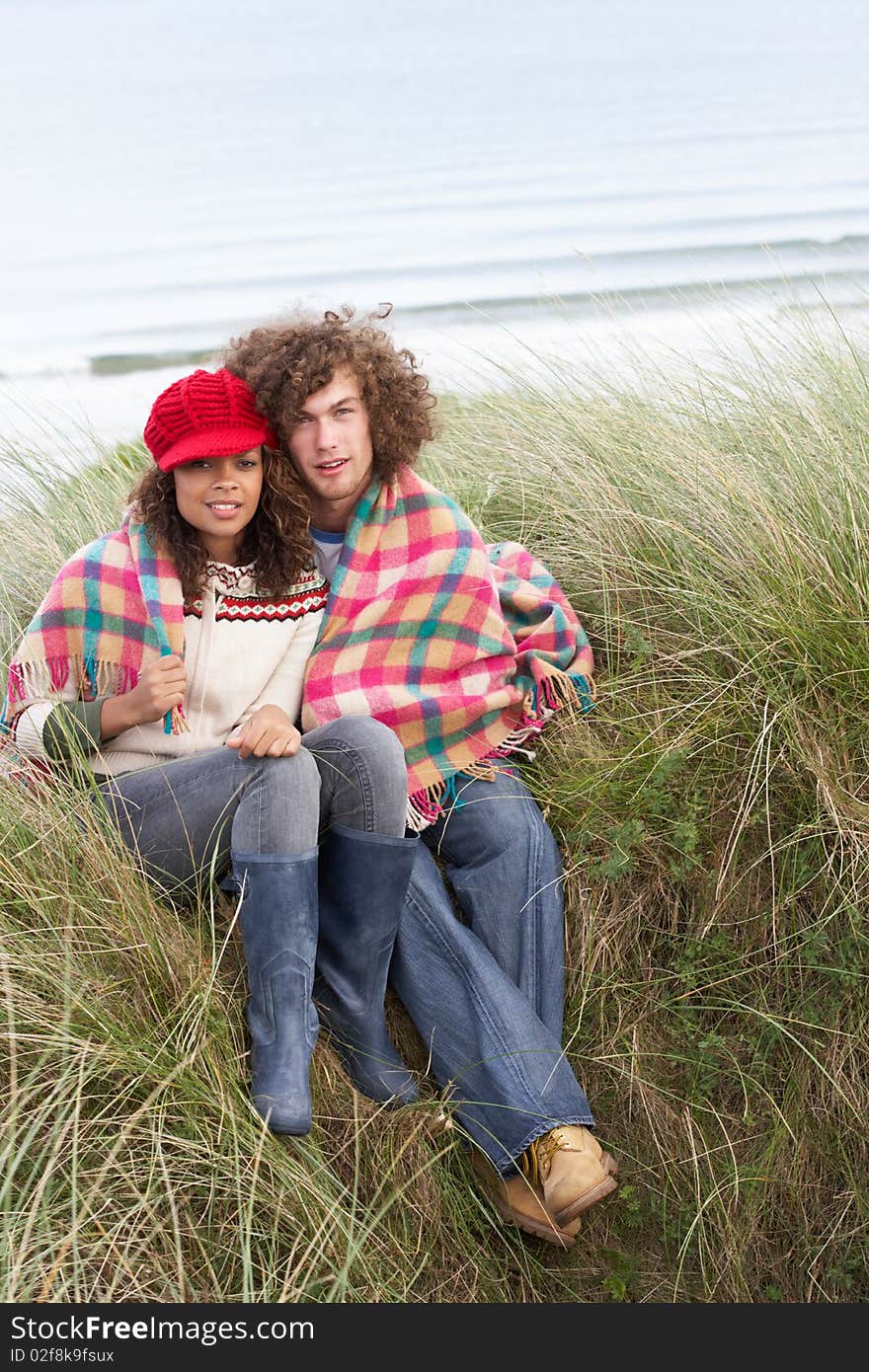 Young Couple Sitting In Sand Dunes