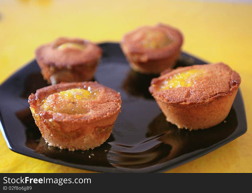 French cake made with some mango caramel, presented on a black plate. French cake made with some mango caramel, presented on a black plate.