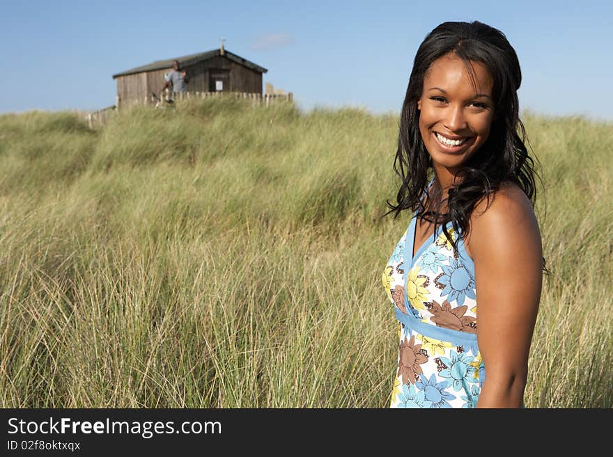 Young Woman Standing On Beach Amongst Dunes