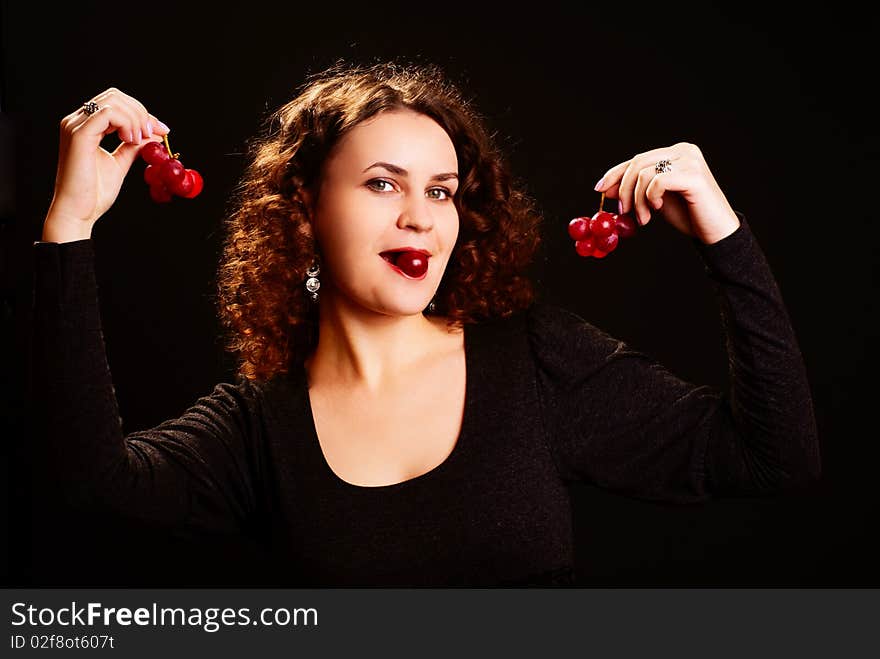 Portrait of beautiful woman with grapes. Black background. Studio shot.