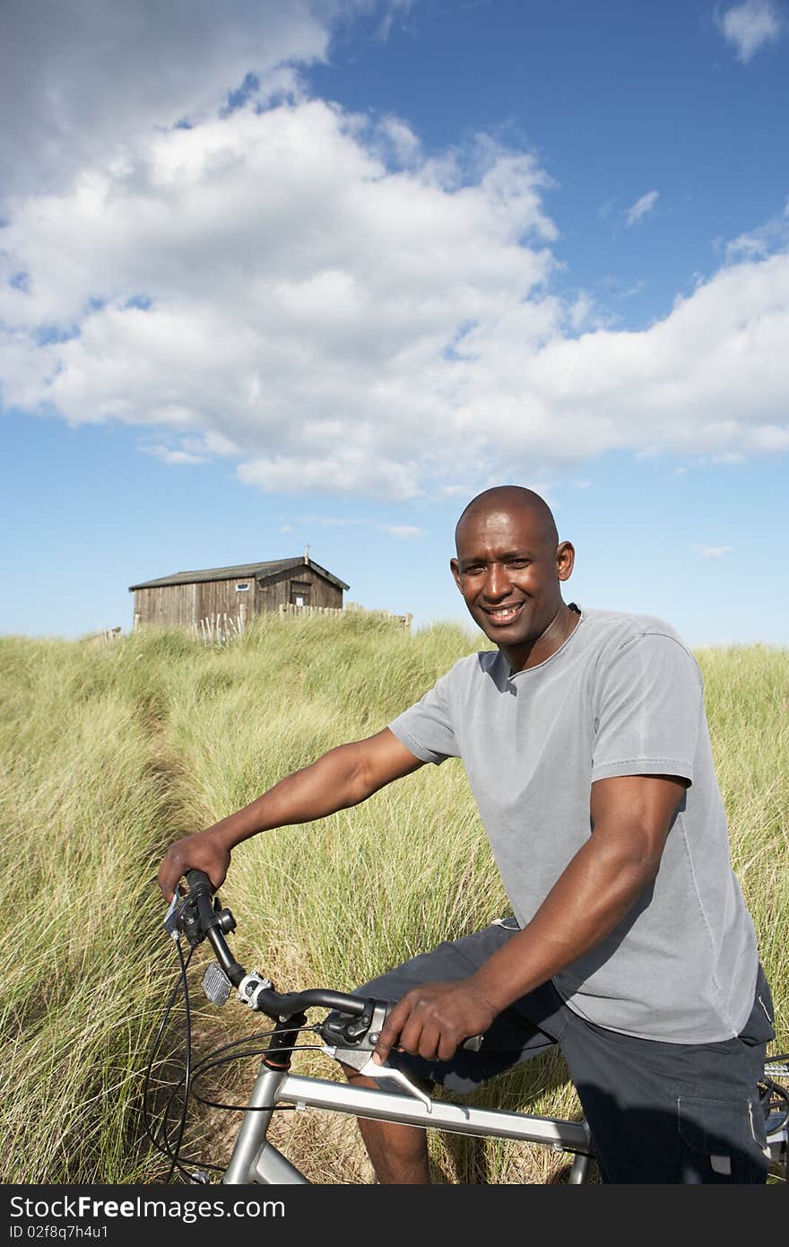 Man Riding Mountain Bike By Dunes