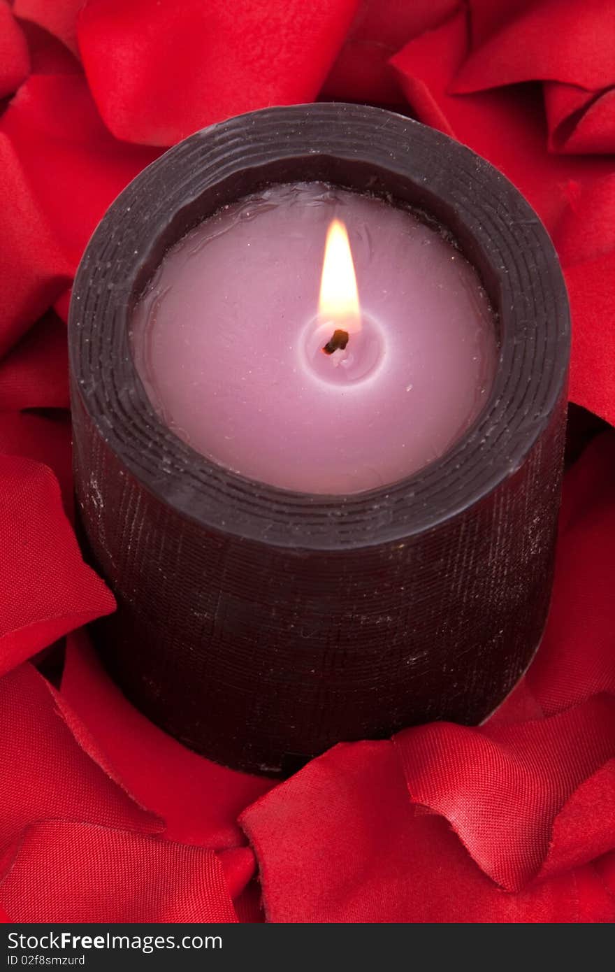 Candle surrounded with red rose petals. Candle surrounded with red rose petals