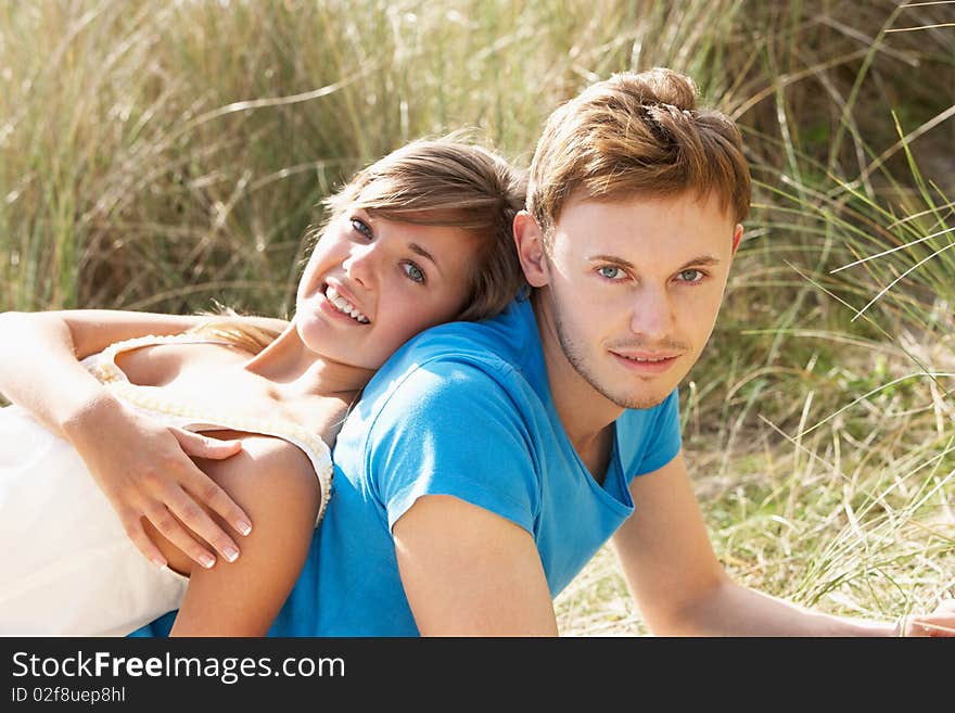 Young Romantic Couple Relaxing On Beach Together