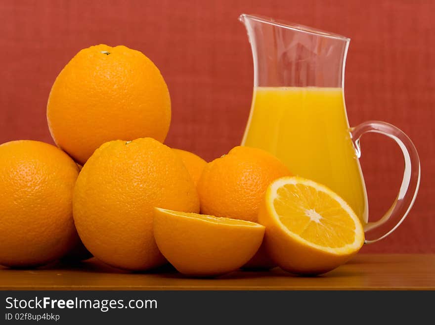 Bunch of oranges and a pitcher of orange juice. Bunch of oranges and a pitcher of orange juice