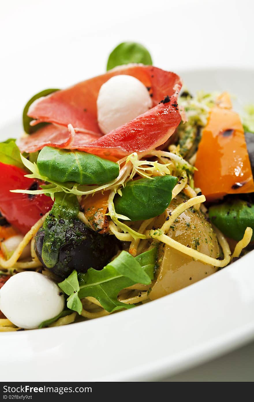 Spaghetti with Vegetables, Ham, Black Olives, Rucola and Pesto Sauce