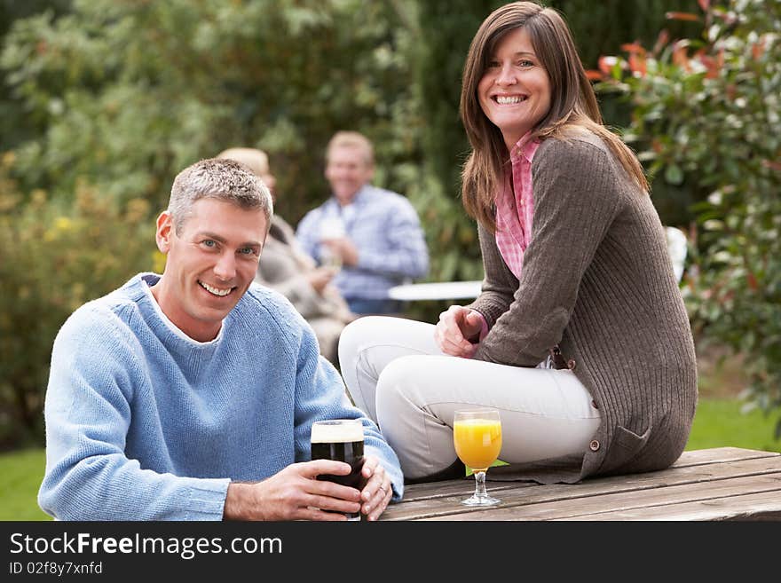 Couple Outdoors Enjoying Drink In Pub Garden. Couple Outdoors Enjoying Drink In Pub Garden