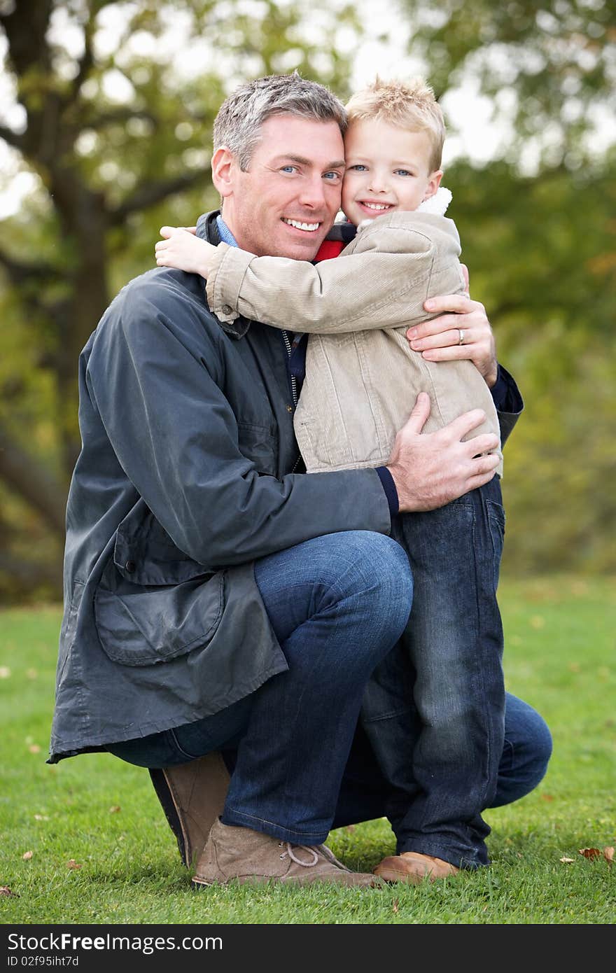 Father And Son Hugging On Outdoor Autumn Walk. Father And Son Hugging On Outdoor Autumn Walk