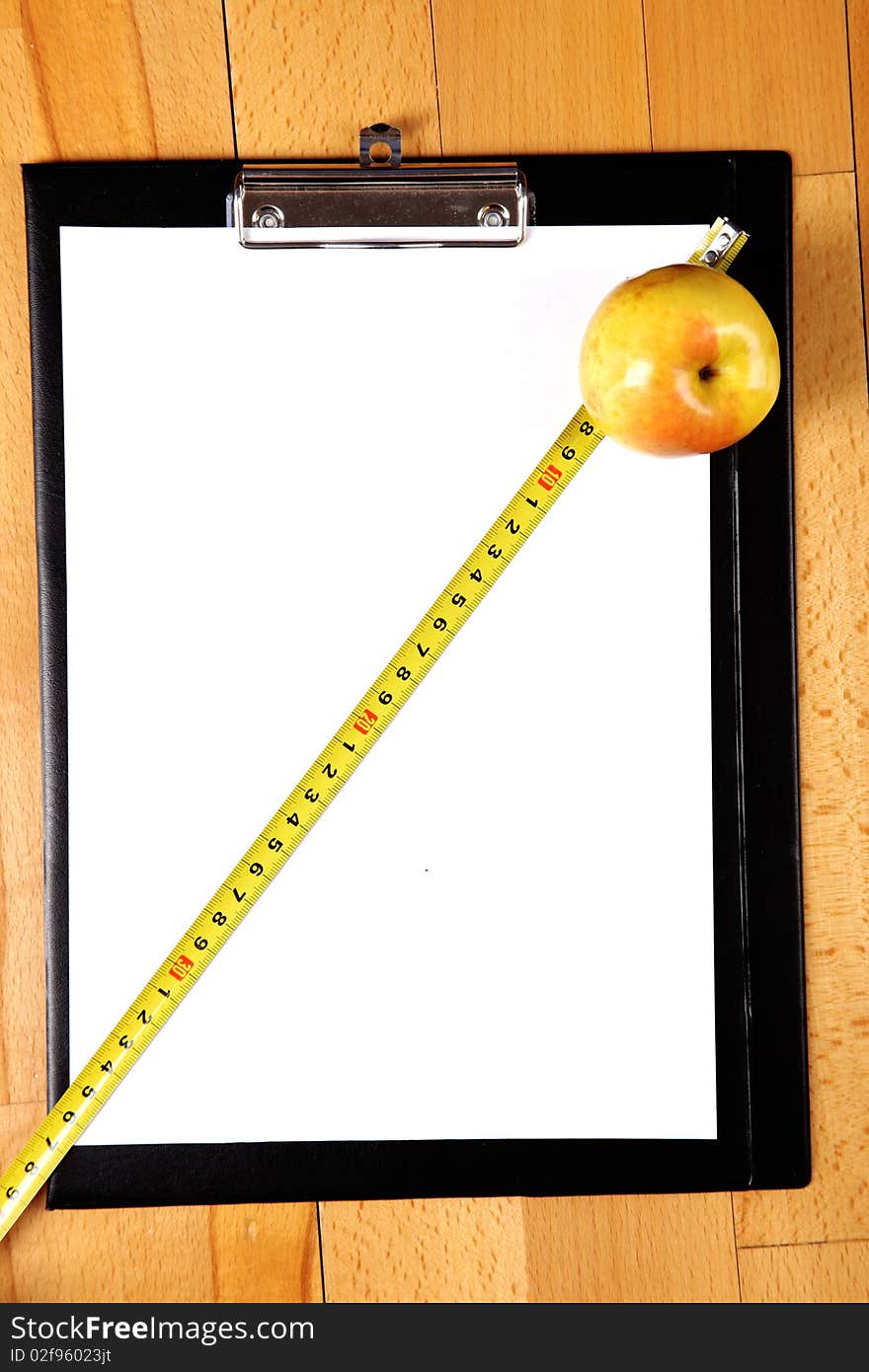 Diet plan - blank clipboard with a measuring tape, apple and copy space