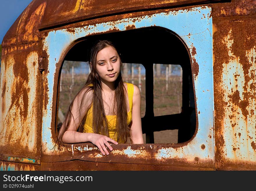 Young woman at the window of an old, rusty bus. Young woman at the window of an old, rusty bus