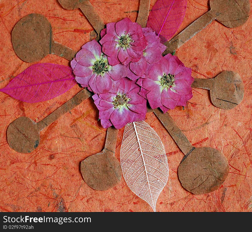 Arrangement of dried roses, skeleton leaves and cutout paper shapes on orange background. Main colours: orange, pink, brown. Arrangement of dried roses, skeleton leaves and cutout paper shapes on orange background. Main colours: orange, pink, brown.