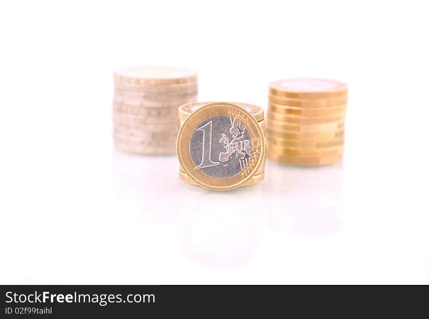 One euro coin with another three pile of euro coins