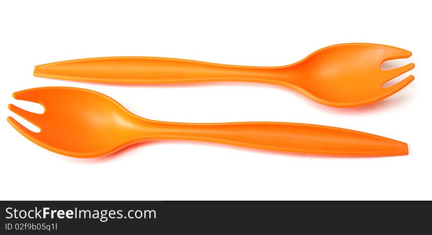 Two plastic orange forks on white background