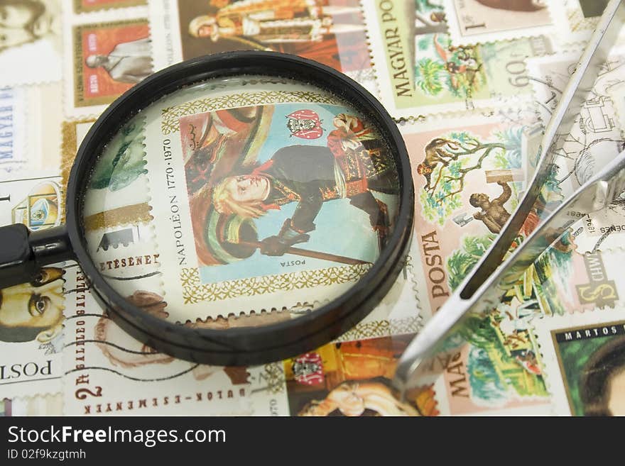 Magnifying glass and postage stamps collection with tweezers. Magnifying glass and postage stamps collection with tweezers.