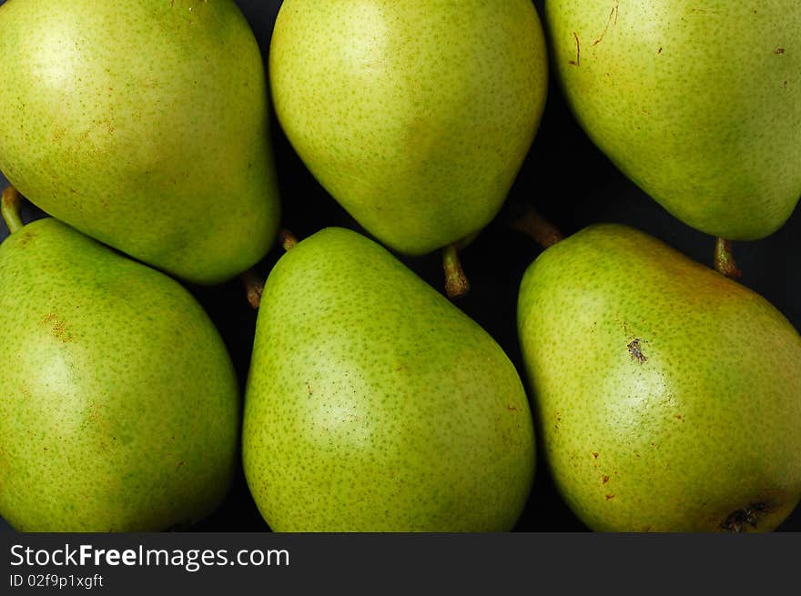 Various green pears on black background