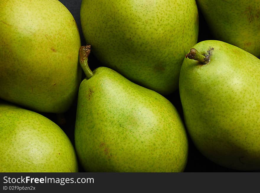 Various green pears on black background