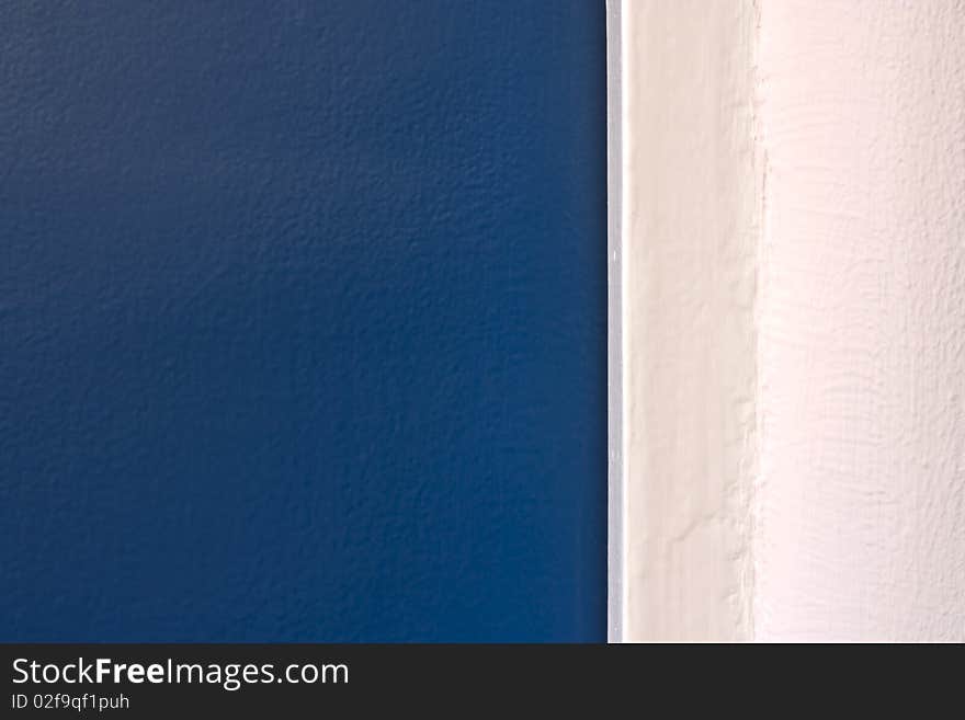 A close-up of a blue painted door and a white painted wall. A close-up of a blue painted door and a white painted wall