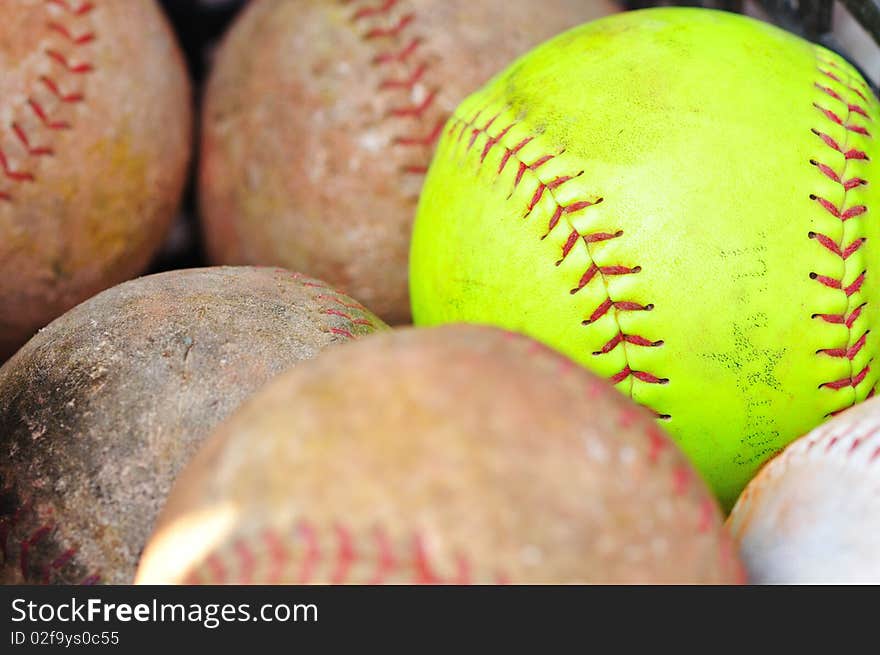 A yellow baseball against brown baseballs