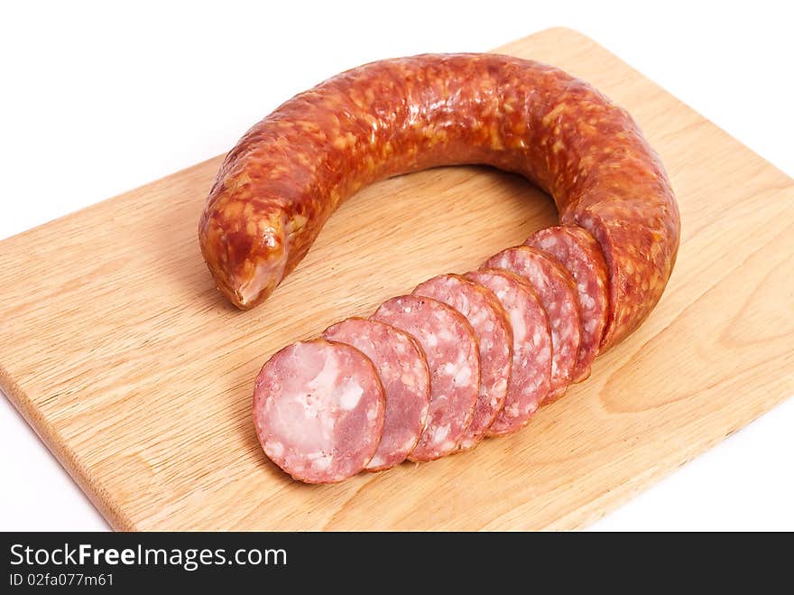 Smoked sausage slices on wooden plate