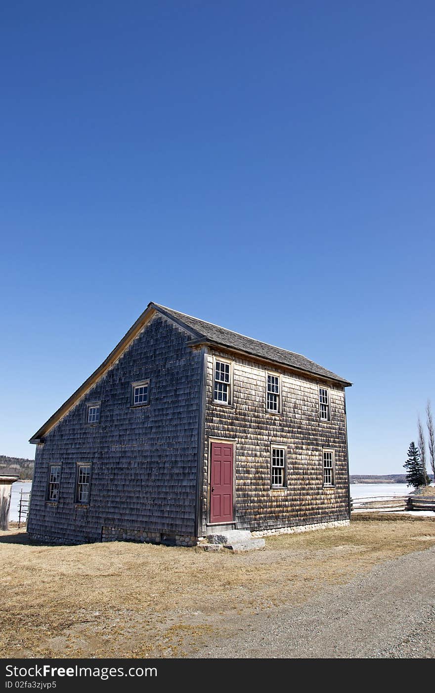 A cedar shake house on the bank of the St. John River in the historic settlement of Kings Landing, New Brunswick - Canada. A cedar shake house on the bank of the St. John River in the historic settlement of Kings Landing, New Brunswick - Canada