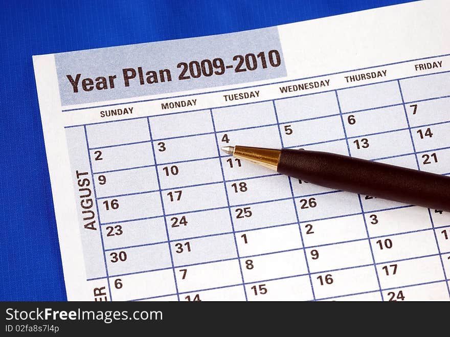 Planning the year on the day planner isolated on blue