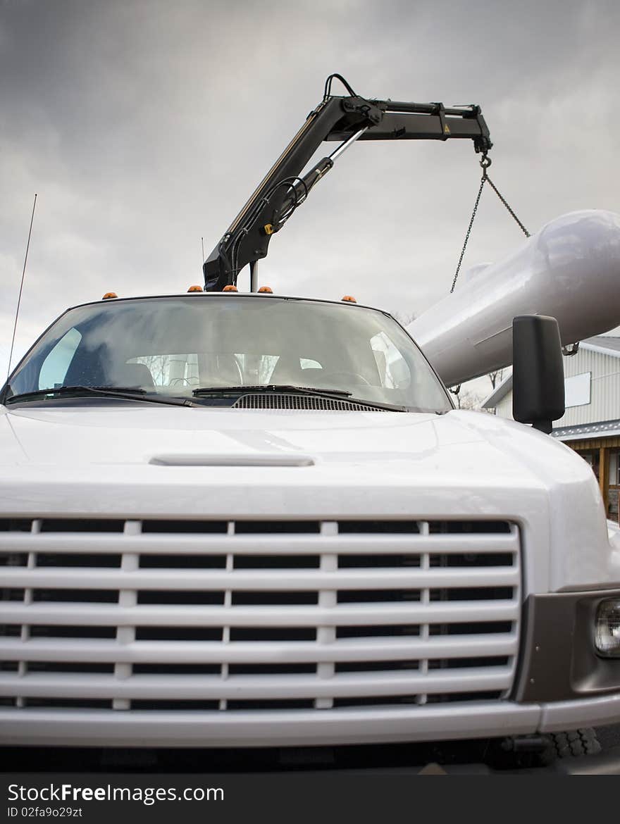 Crane in operation lifting a large gas tank