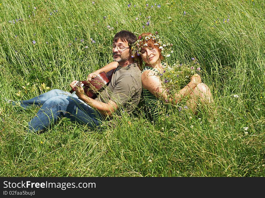 Air sits on meadow with guitar