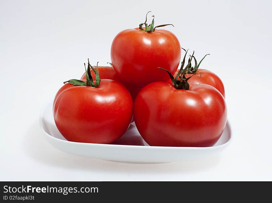 Red tomatoes on a white plate