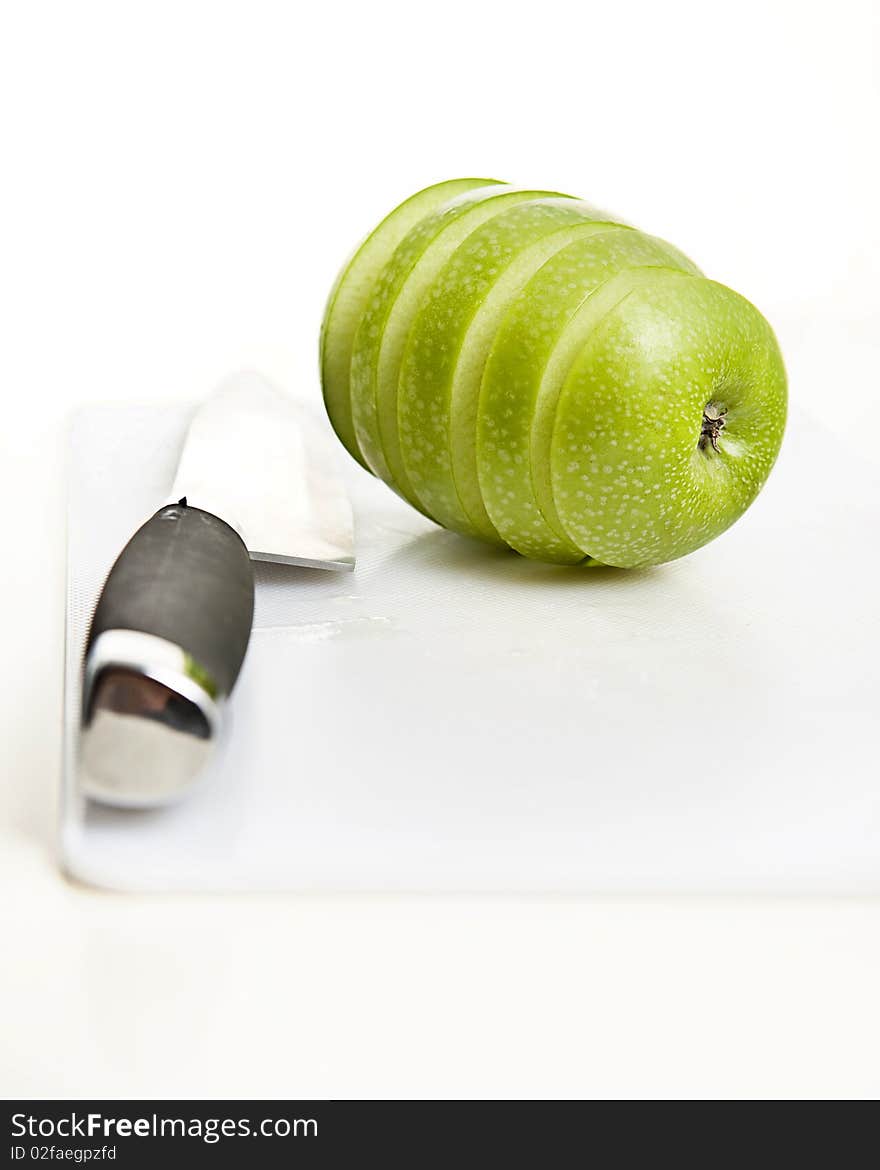 Sliced green apple in multiple peices with knife. Sliced green apple in multiple peices with knife